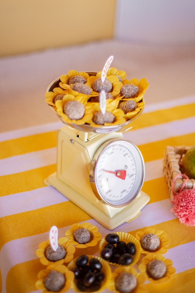 Balança de feira amarela servindo doces e jabuticabas